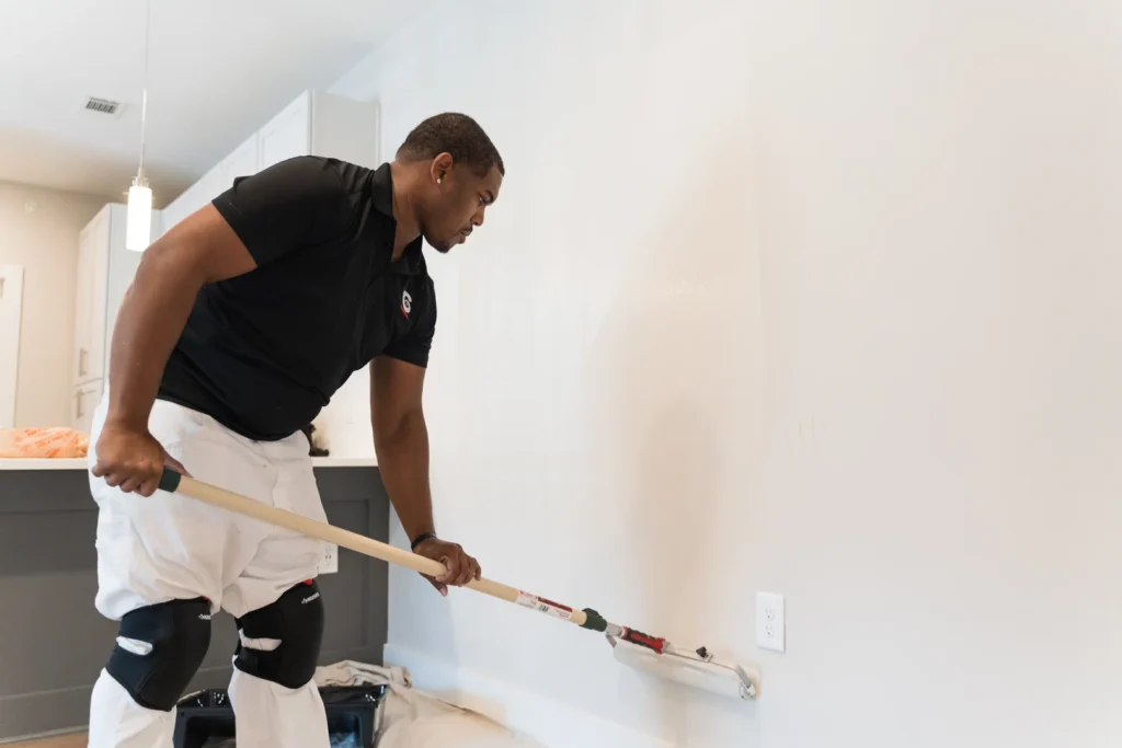 painter applying smooth wall primer in a modern apartment